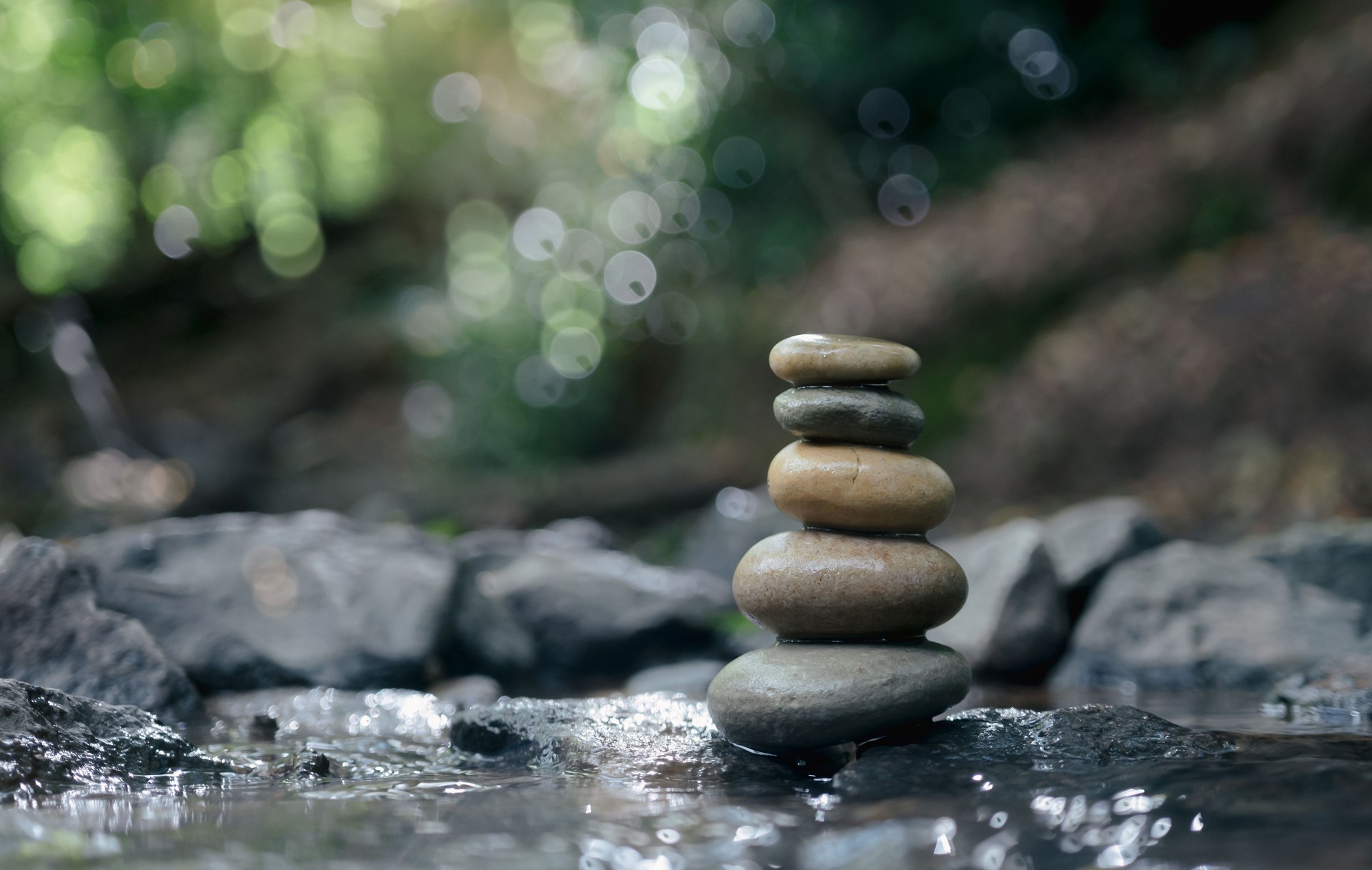 Stack of zen stones, Close up of pebble rocks stacked on top of each other in stream leading to a waterfall in a forest, Zen like concepts